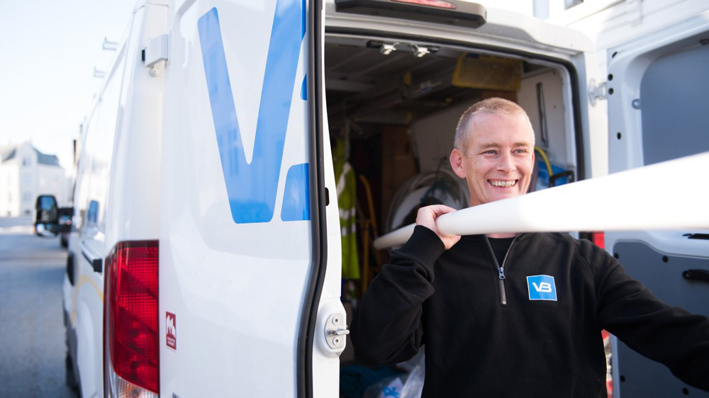 VB-rørlegger bærer rør ut av bilen